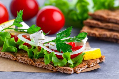 Peynir, domates, marul, soğan, taze maydanoz ve dereotu ile net sandviç. Aperatif ekmek ve fitness yeme. Gevrek ekmek çavdar ve buğday ve pirinç ekmek