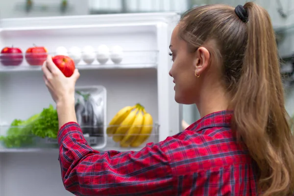 魅力的な女の子は新鮮なリンゴ 冷蔵庫からおやつを取り出します 食品貯蔵庫 冷蔵庫に 適切な健康的な新鮮な料理 — ストック写真
