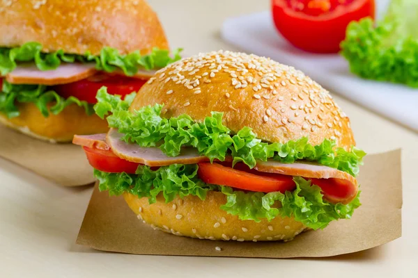Taze marul, domates, jambon için meze ile iştah açıcı susam buns. Ev yapımı sandviçler