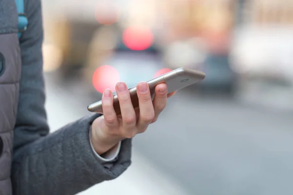 Mujer Sostiene Teléfono Móvil Fondo Ciudad Comunicaciones Aplicaciones Móviles Dependencia —  Fotos de Stock