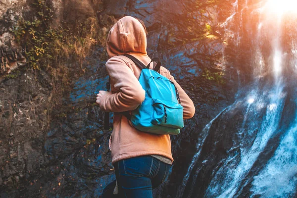 Mujer Joven Viajera Con Una Mochila Azul Eleva Una Cascada — Foto de Stock