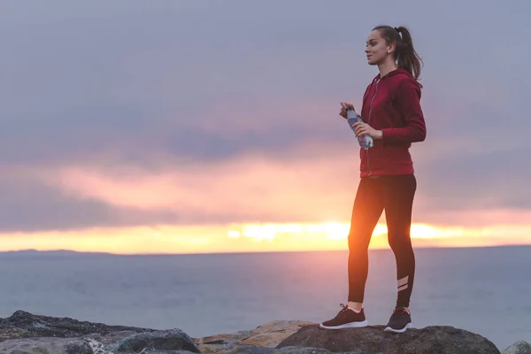 Fitness Dziewczyny Trampki Stojąc Kamień Trzymając Butelkę Wody Patrząc Dal — Zdjęcie stockowe