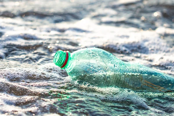 Plastic bottle in the sea. Discharge of plastic waste into the sea. Environmental and water pollution