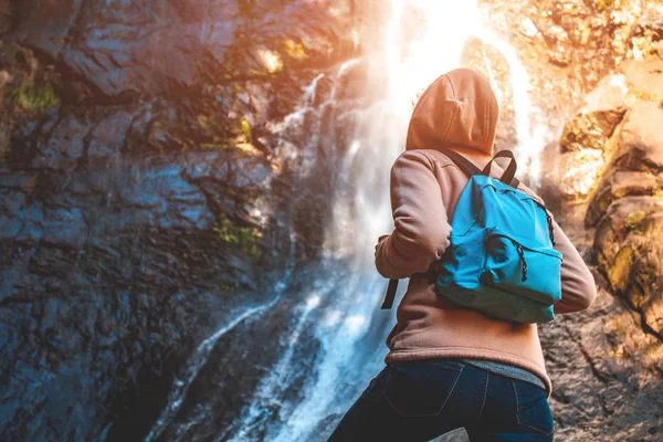 Mujer Joven Viajera Con Una Mochila Azul Eleva Una Cascada — Foto de Stock