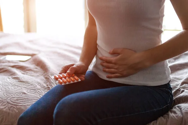 Young woman feels bad and experiences abdominal pain during the period of PMS and menstruation. Painful menstruation. Inflammation and Bladder Infection