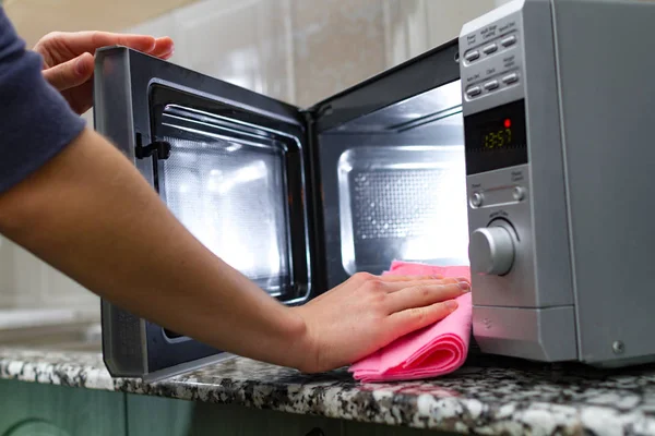 Housewife cleaning microwave oven
