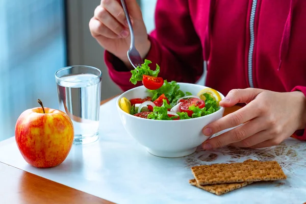 Genç kadın net çavdar ekmeği ile sağlıklı, taze, sebze Salata yiyor. Diyet ve sağlıklı yaşam konsepti. Diyet yemekleri. Doğru beslenme ve doğru yemek 