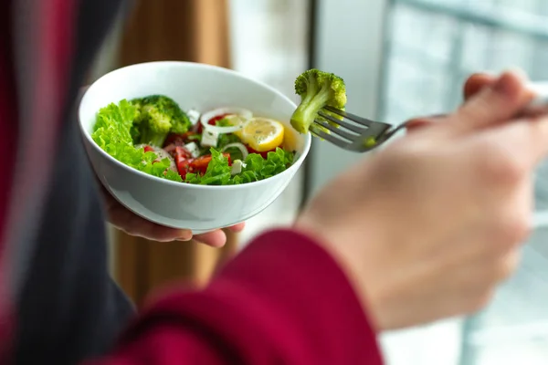 Young fitness woman eating a healthy salad after a workout. Fitness and healthy lifestyle concept.