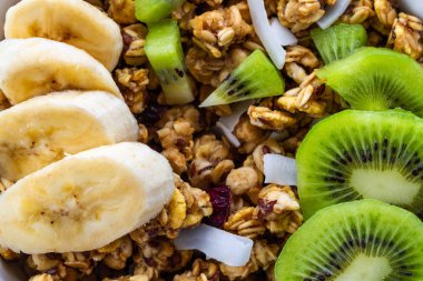 Kahvaltılık kuru. Gevrek tatlım müsli dilim taze muz ve kivi ile kapatın. Sağlıklı ve lif yiyecek. Müsli arka plan ve doku 