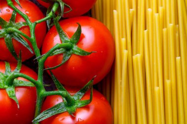 Pişmiş Kurutulmuş spagetti ve taze domates dokusu. İtalyan gıda konsepti. Makarna pişirme için malzemeler.