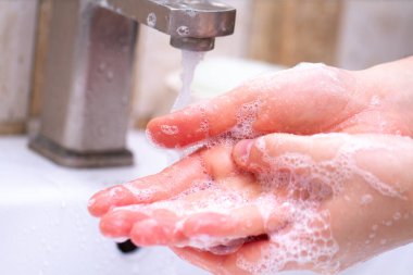El hijyeni. Kişi tuvalette temizlik ve sabun köpüğü kullanarak el yıkama