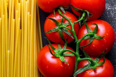 Pişmiş Kurutulmuş spagetti ve taze domates dokusu. İtalyan gıda konsepti. Makarna pişirme için malzemeler.