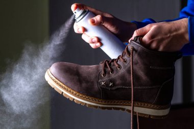 Bir kişi temizlik ve nem ve kir koruma için Erkek süet gündelik botlar üzerinde Ajan püskürtme. Ayakkabı Parlatıcı 
