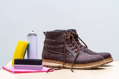 Sünger, fırça ve sprey ile erkek süet gündelik botlar Temizleme. Ayakkabı parlıyor. Ayakkabı nemi ve kir koruması