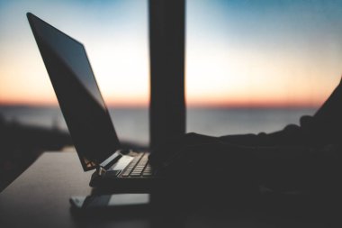 Çevrimiçi bir dizüstü bilgisayar kullanarak evde çalışıyor. Rahat workpl silueti