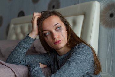 Depresif, üzgün, yalnız kadın yatağa yakın oturan ve iş ve ilişkilerde sorunlar sorunları nedeniyle ağlıyor. Yerli, kadın şiddet. Yaşam problemleri 