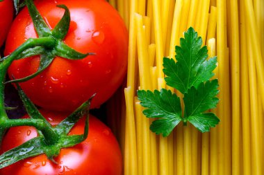 Doku kuru spagetti, maydanoz ve taze domates. İtalyan gıda kavramı. Makarna yemek pişirmek için malzemeler. 