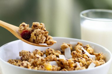 Kahvaltılık kuru. Keten tohumu, kızılcık, Hindistan cevizi granola kase gevrek bal ve bir bardak süt kapatın. Sağlıklı, temiz ve fiber yiyecek. Kahvaltı saati 