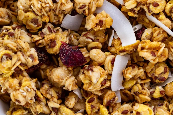 Dry breakfast cereals. Texture of crunchy honey granola with flax seeds, cranberries and coconut. Healthy and fiber food. Muesli background and texture