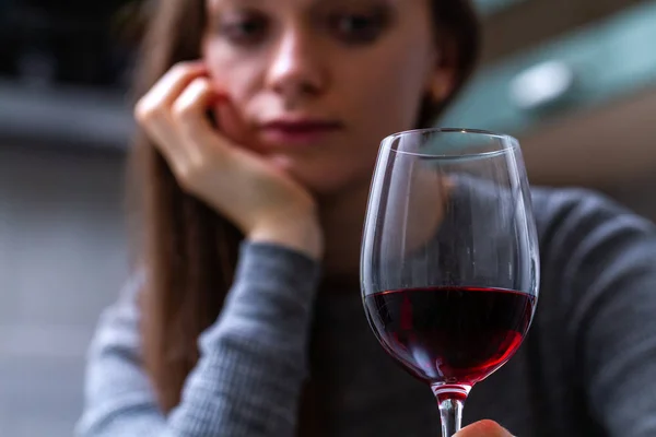 Depressed, divorced crying woman sitting alone in kitchen at hom