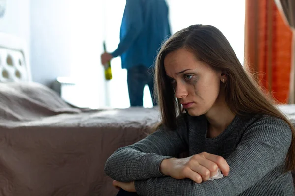 Domestic, female violence. Crying woman sitting near the bed after an argument with her husband. Social and life problems