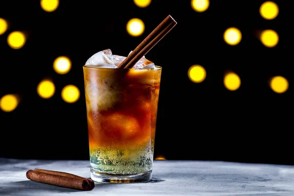 Uppfriskande Cocktail Med Isbitar Bubblor Kanel Och Läsk Bakgrunden Lampor — Stockfoto