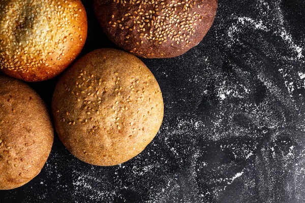 黑色背景上的黄色和棕色芝麻面包 顶部视图 面粉和烘焙产品 新鲜的面包复制空间 — 图库照片