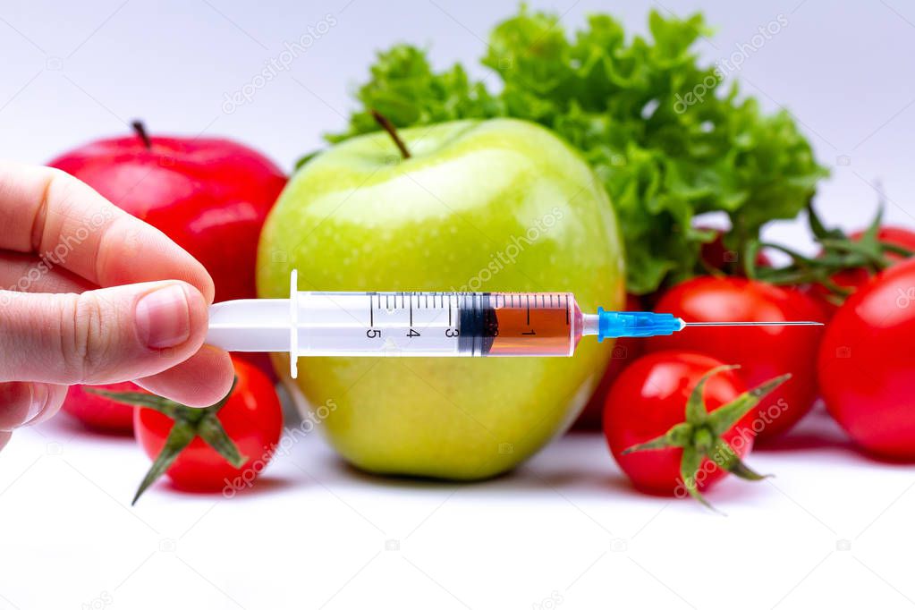Pesticides and nitrates are injected into vegetables and fruits with a syringe. Gmo concept and genetically modified organism. Gmo free and natural healthy products without chemical additives. 