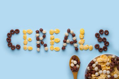 Tahıllar kase ve mavi bir arka plan üzerinde kaşık. Sırlı, çikolata b