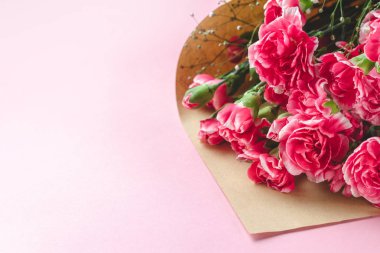 Pembe backgr üzerinde zanaat kağıt taze karanfil çiçek Buket