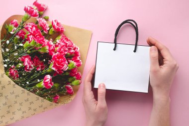 Taze karanfil buketi ve pembe b bir kağıt beyaz hediye çantası