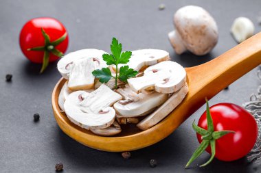 Tahta kaşıkta taze dilimlenmiş beyaz champignon. Ev yapımı yemek pişirme 