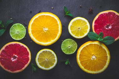 Taze, olgun narenciye ve yeşil nane koyu arka plan üzerinde yaprakları. Sağlıklı yemek ve diyet. Vitaminler ve vitaminler