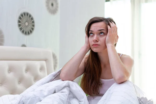 Sad unhappy woman suffering and disturbed by noisy neighbors and