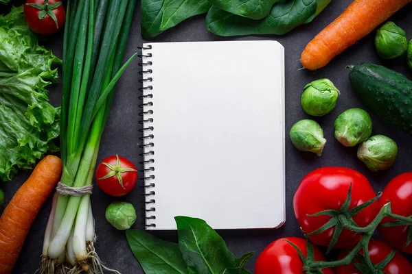 Blanco receptenboek en verschillende rijpe groenten om vers te koken — Stockfoto