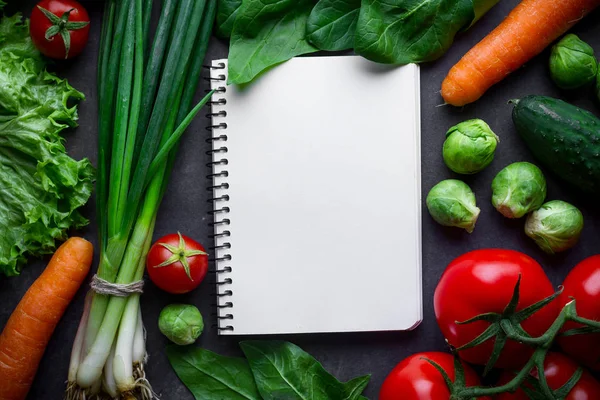 Livro de receitas em branco e vários vegetais maduros para cozinhar fresco — Fotografia de Stock