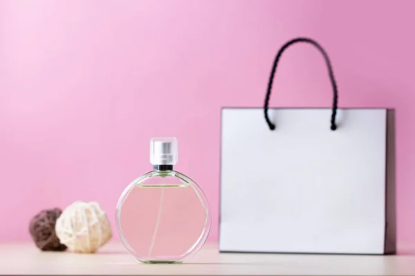 Botella de perfume favorito de mujer y una bolsa de papel de regalo en un alfiler — Foto de Stock