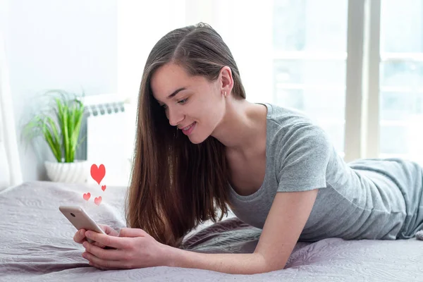 Jeune, attrayant, femme célibataire bavarder par téléphone sur le réseau social — Photo