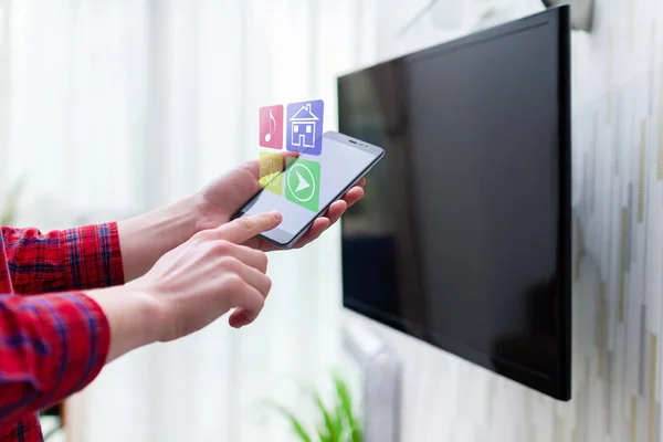 Control en línea de Smart TV por wifi utilizando una aplicación móvil en el teléfono inteligente —  Fotos de Stock