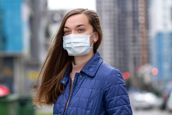 Woman in medical mask on street. Protection against virus, infec