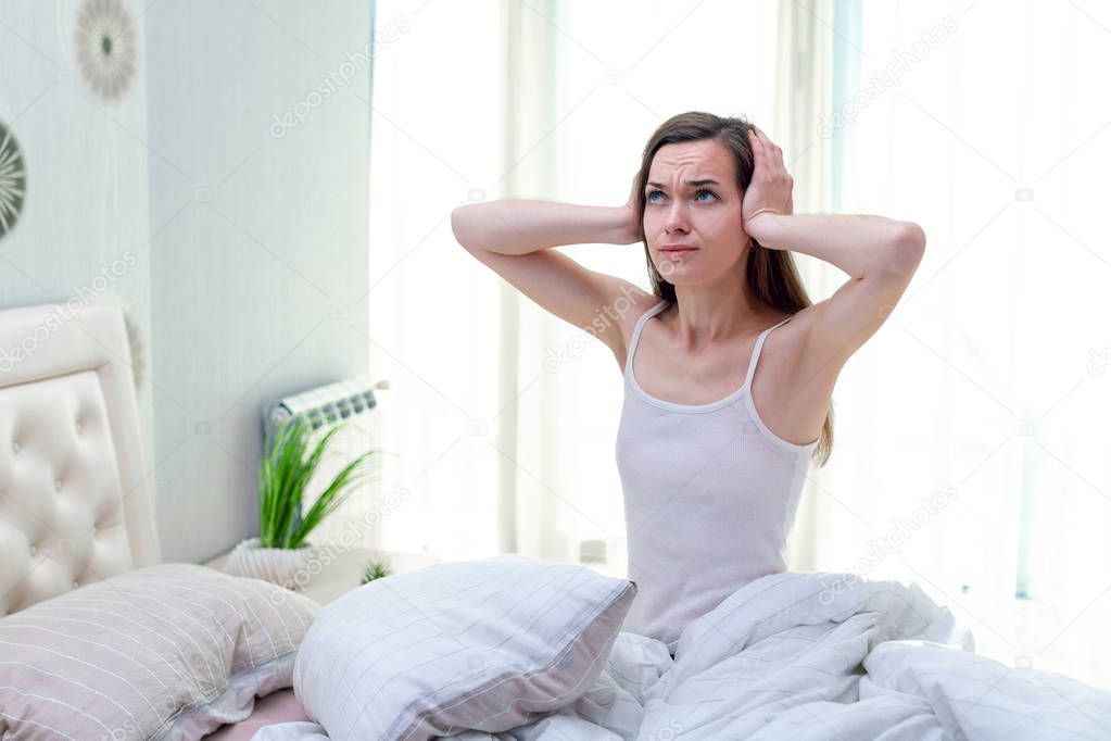 Young woman suffering and disturbed by noisy neighbors and cover