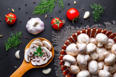 Siyah bir arka plan üzerinde tahta kaşıkta taze dilimlenmiş champignon. C