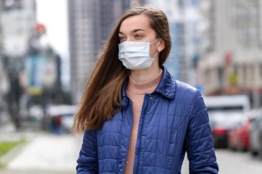 Sokakta maske takan bir kadın. Virüse karşı koruma, 