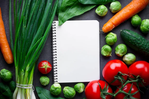 Reife Zutaten und leeres Rezeptbuch zum Kochen von frischem Salat — Stockfoto