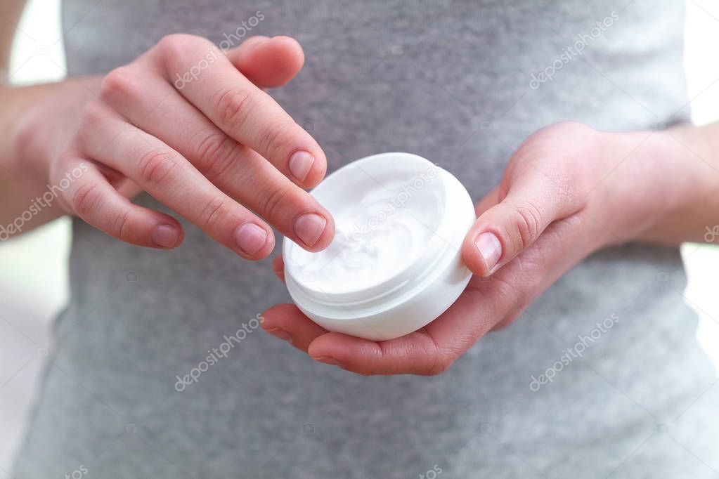 Skin care. Daily application of moisturizer on dry hand skin at 