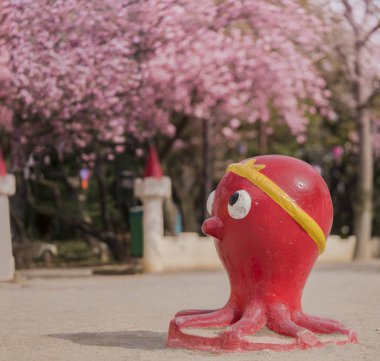 Asukayama Park Kita bölgesinde, Tokyo kuzeyinde kiraz çiçekleri bakarak komik kırmızı ahtapot heykel.