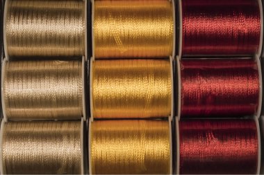 Kesme doku portre renkli dikiş konu altın, sarı ve kırmızı bobinler üzerinde.