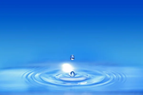 Nahaufnahme Auf Doppelten Wassertropfen Die Eine Blaue Flüssigkeit Fallen Und — Stockfoto