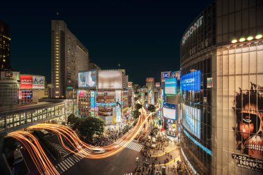 Tokyo, Japonya - 20 Temmuz 2018: Havadan görünümü Shibuya Crossing kesişme Shibuya İstasyonu önünde bir yaz gecesinde araçların hız ışık akışı ile.
