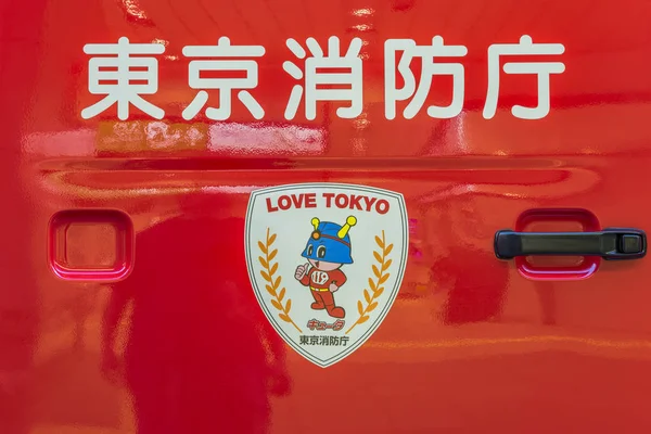 Tokyo, Japonya - 18 Ağustos 2018: Bir kırmızı Japon yangın kamyon kapı kolu ile baþlayabilir Tokyo itfaiye ve itfaiyeci maskotu ile 119 göğüs ve aşk Tokyo sloganı bir arma etiket acil telefon numarasını belirten görünümünü.